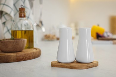 Photo of Ceramic salt and pepper shakers on white countertop in kitchen, space for text