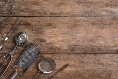 Cooking utensils on wooden table, flat lay. Space for text