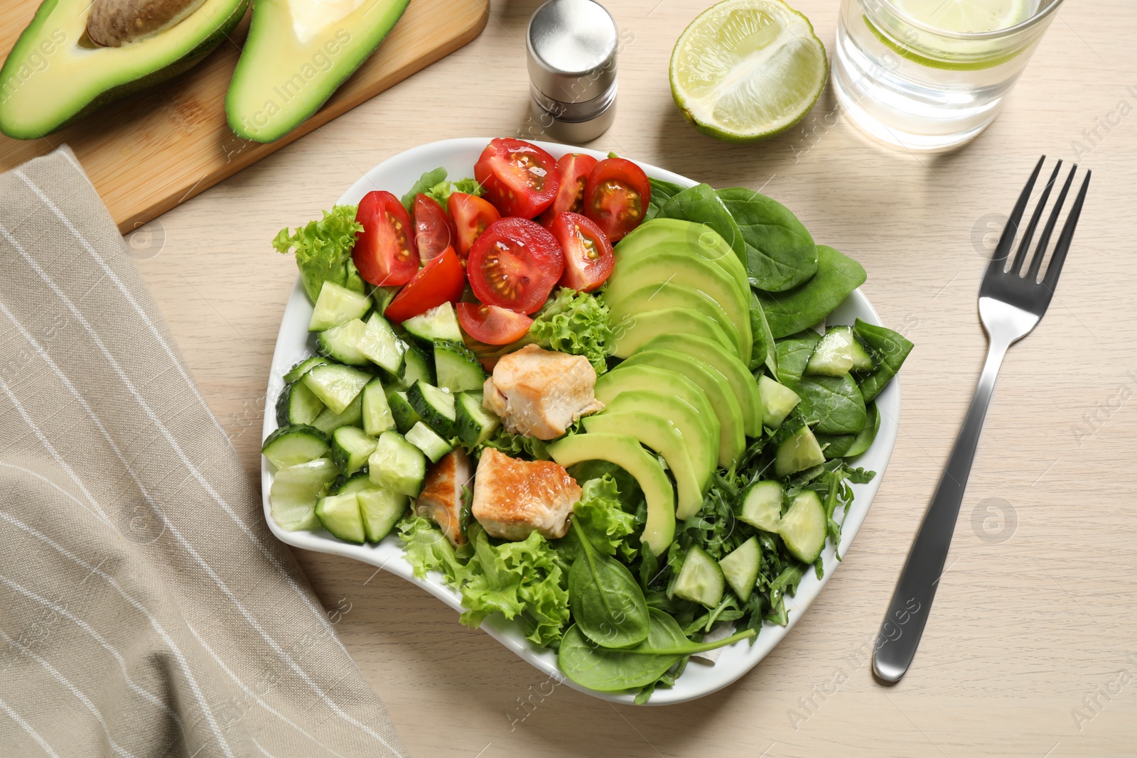 Photo of Delicious avocado salad with fried chicken on wooden table, flat lay