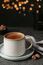 Photo of Delicious coffee with nutmegs on grey table
