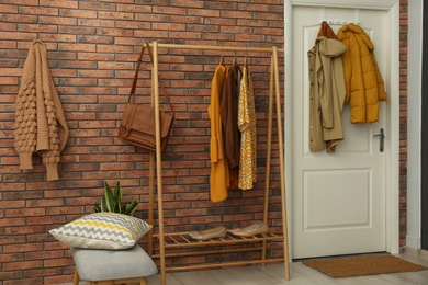 Photo of Hallway interior with stylish furniture, clothes and accessories