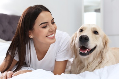 Image of Happy woman with her cute pet dog at home