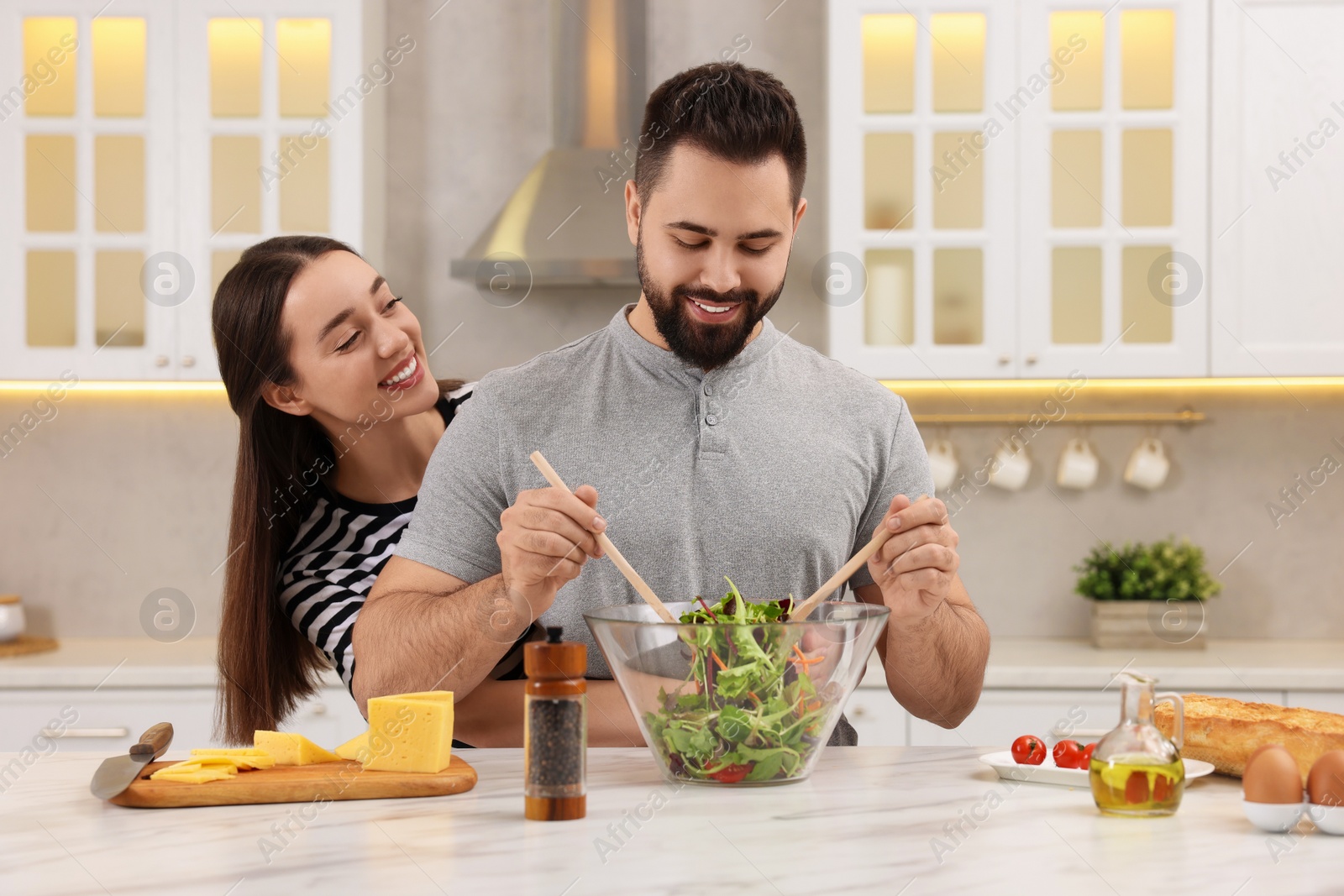 Photo of Lovely young couple cooking together in kitchen