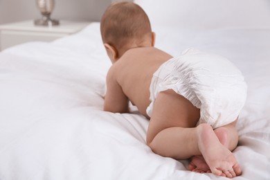 Photo of Cute baby in dry soft diaper on white bed, back view. Space for text