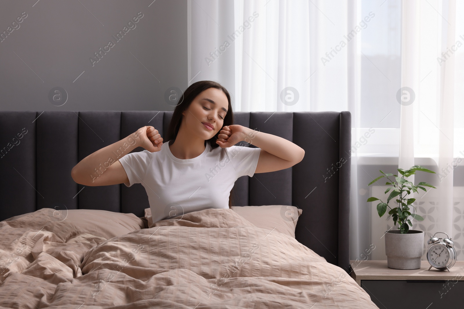 Photo of Beautiful woman stretching in bed at home. Lazy morning