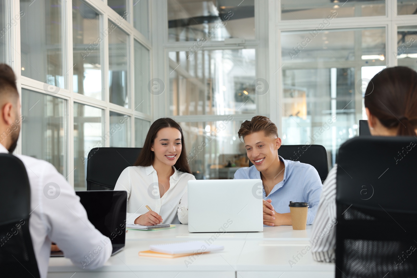 Photo of Colleagues working together in open plan office