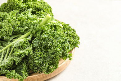 Fresh kale leaves on light grey table, closeup. Space for text