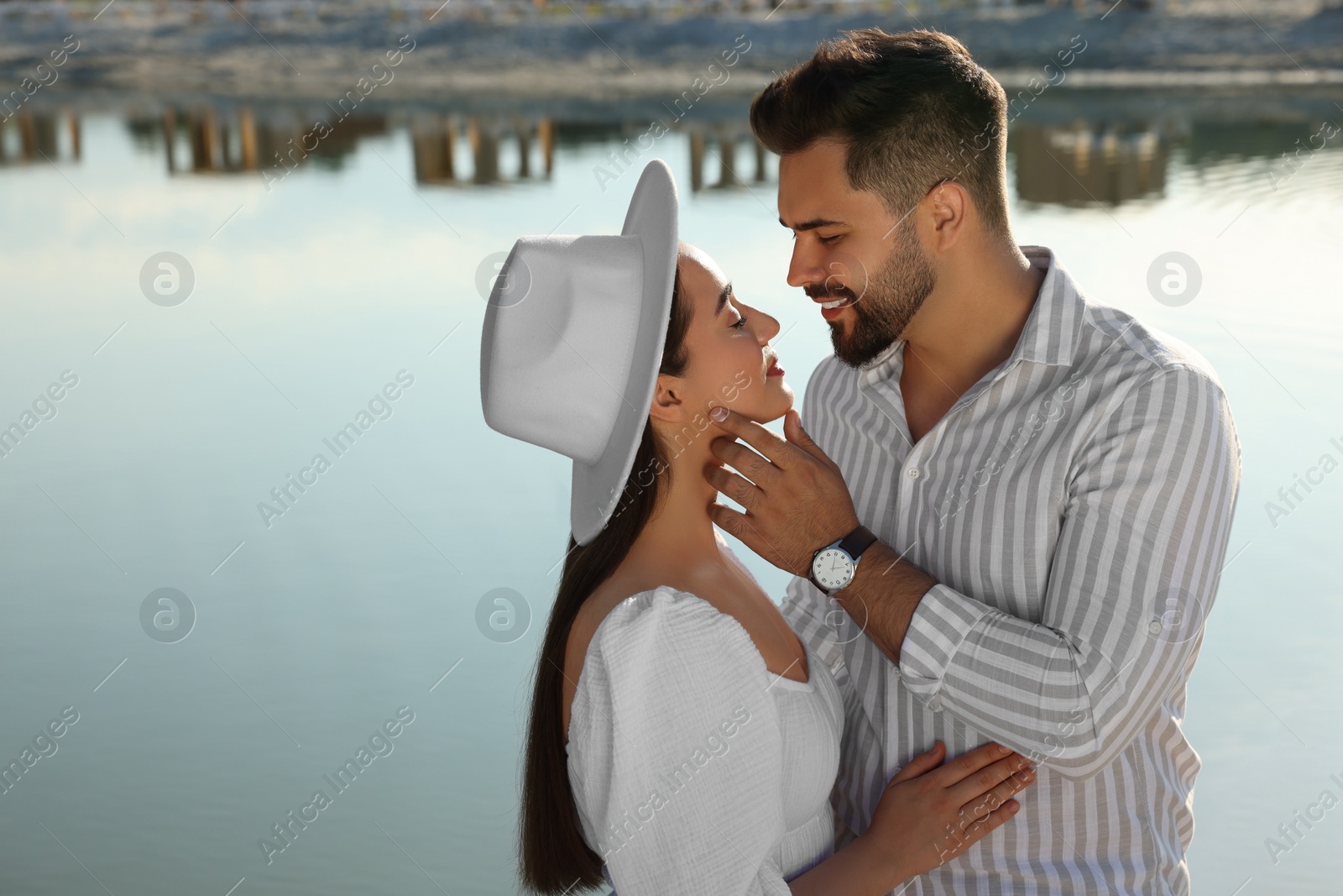 Photo of Romantic date. Beautiful couple spending time together near lake, space for text