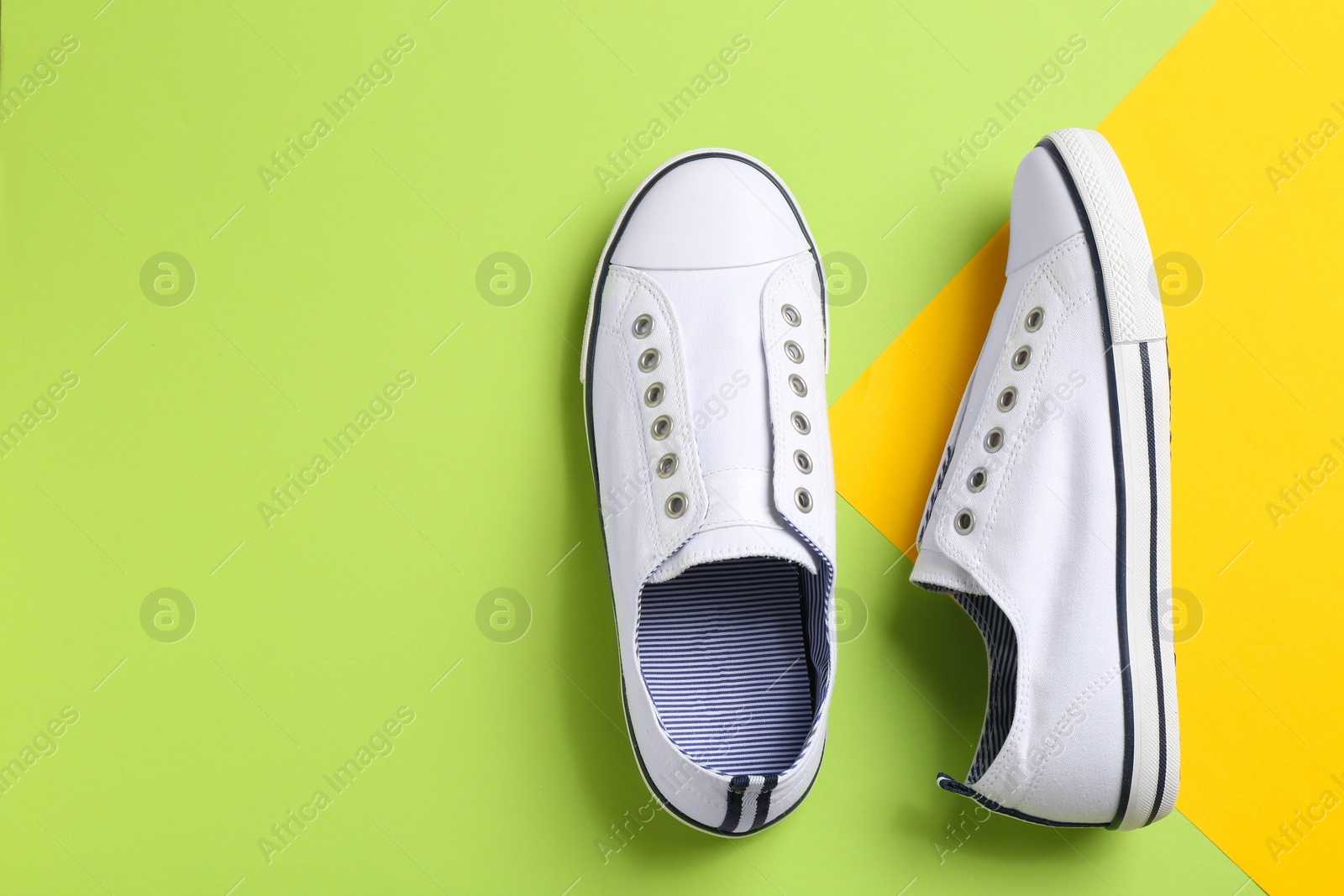 Photo of Pair of stylish sneakers on color background, top view with space for text