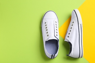 Photo of Pair of stylish sneakers on color background, top view with space for text