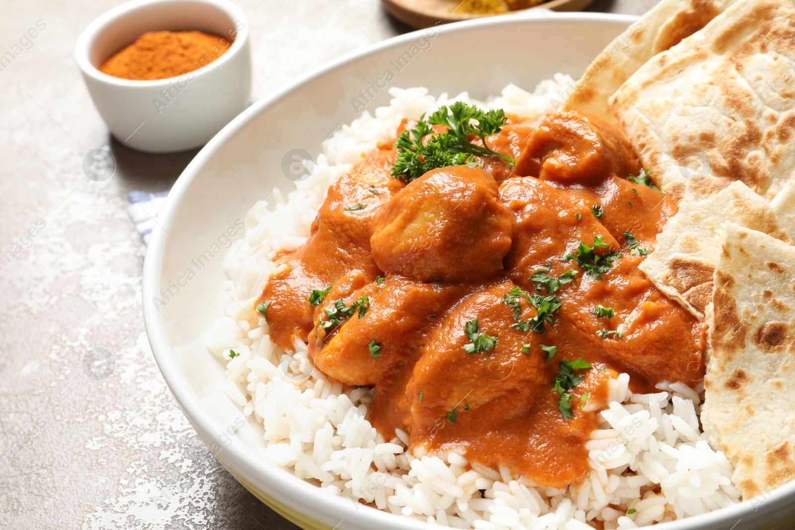 Photo of Delicious butter chicken with rice in plate on table, closeup