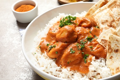 Delicious butter chicken with rice in plate on table, closeup