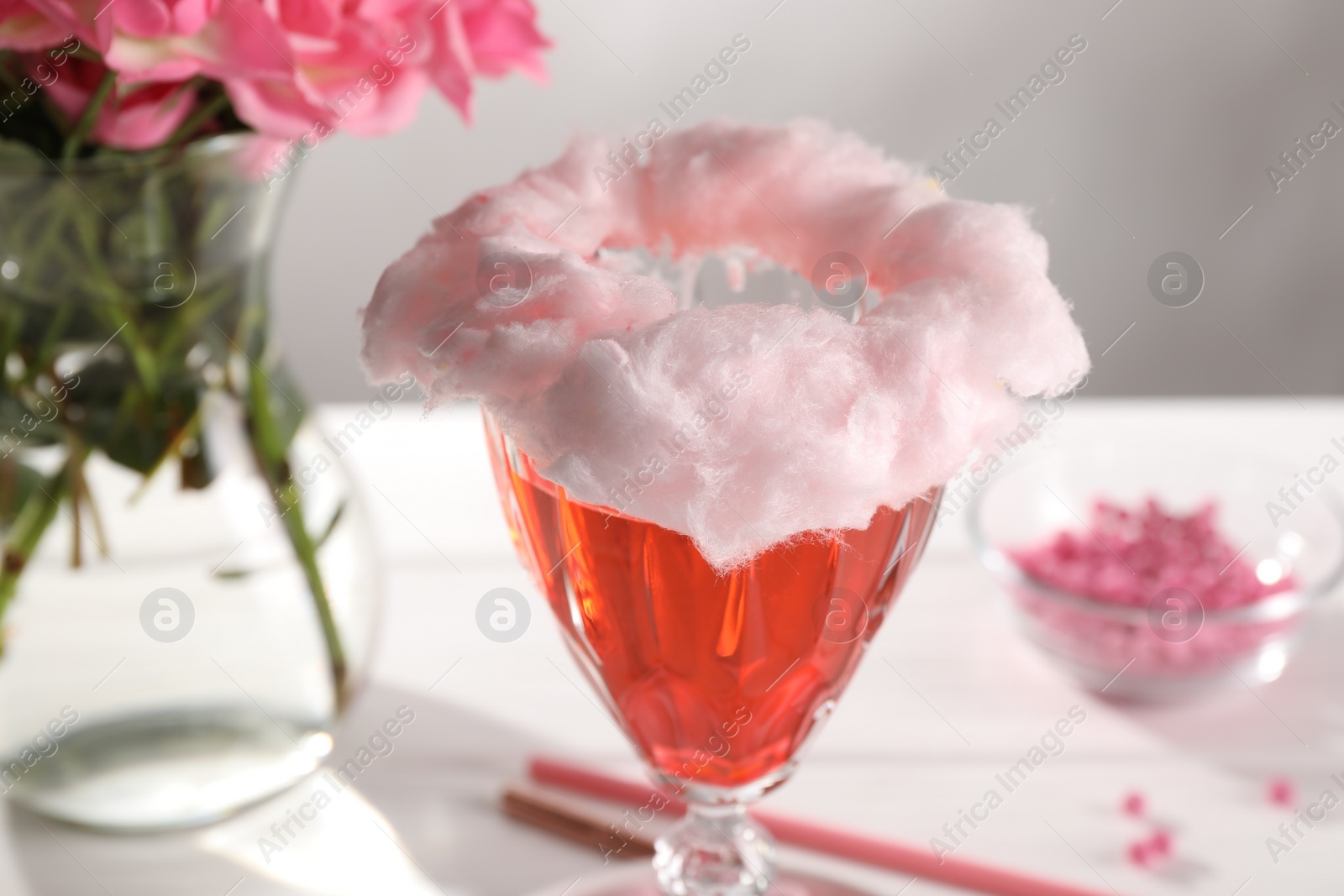 Photo of Cotton candy cocktail in glass on white table, closeup