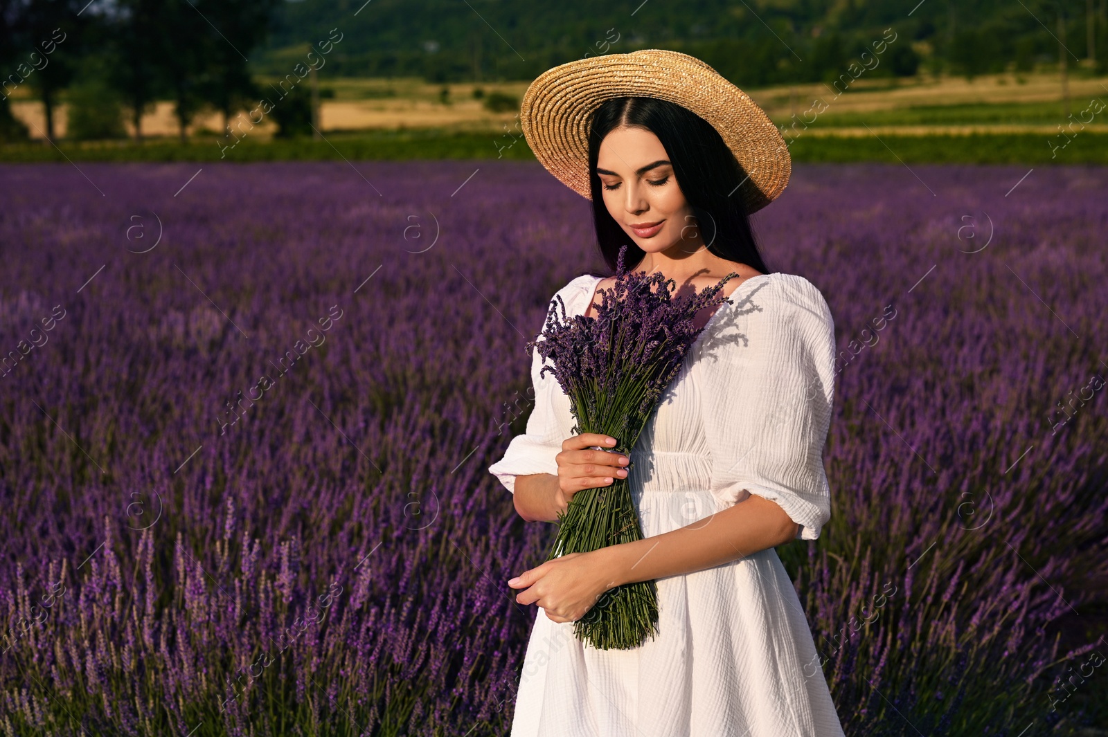 Photo of Beautiful young woman with bouquet in lavender field