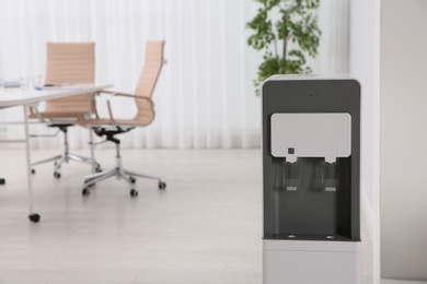 Photo of Modern water cooler in stylish office interior. Space for text