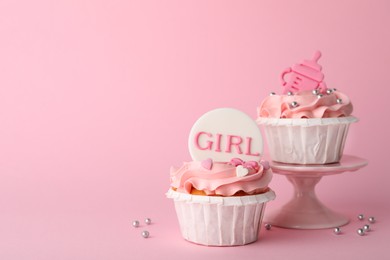 Photo of Baby shower cupcakes with toppers on pink background, space for text