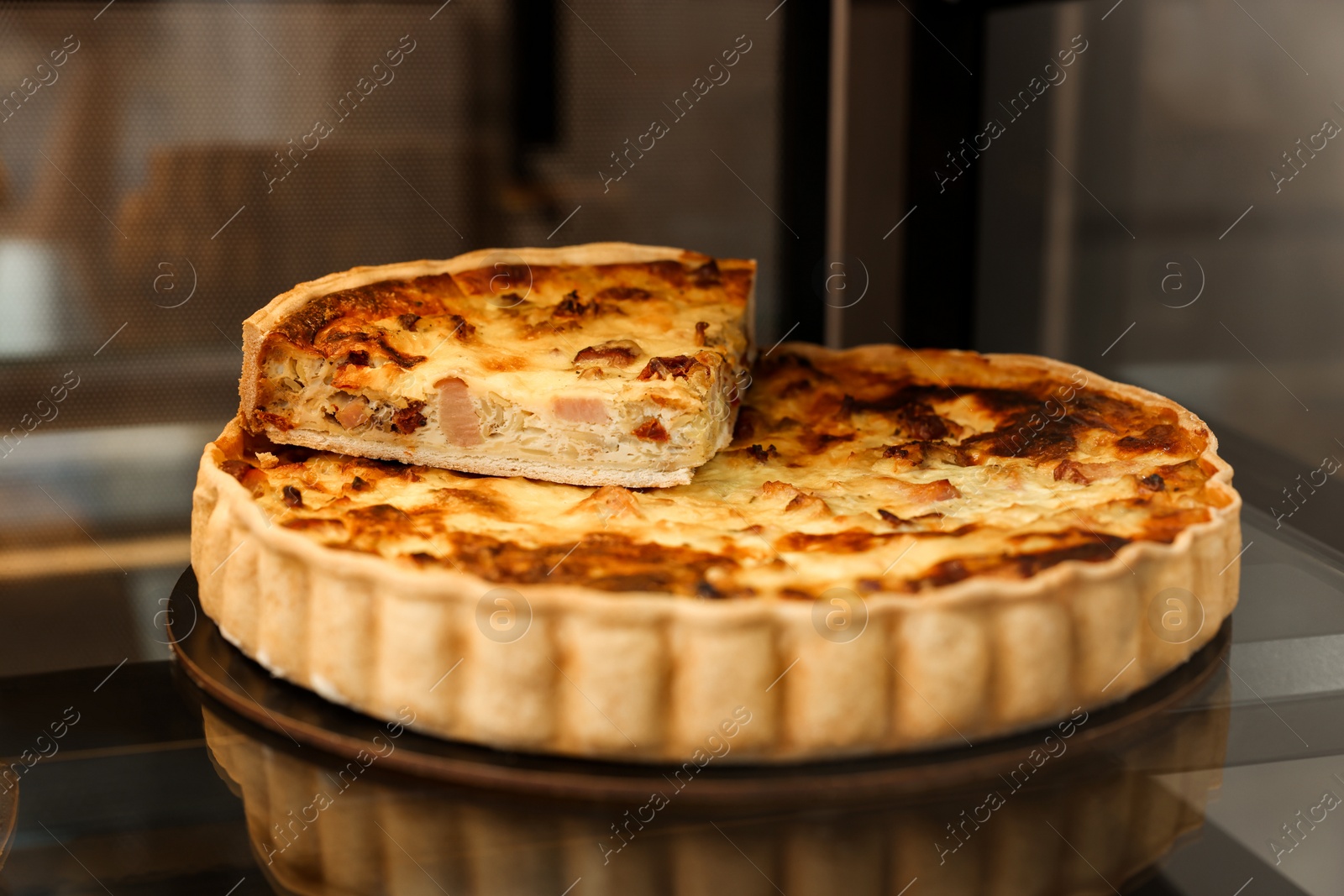 Photo of Delicious meat quiche on counter in bakery shop, closeup