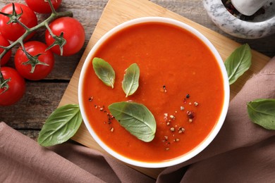 Photo of Delicious tomato soup on wooden table, flat lay