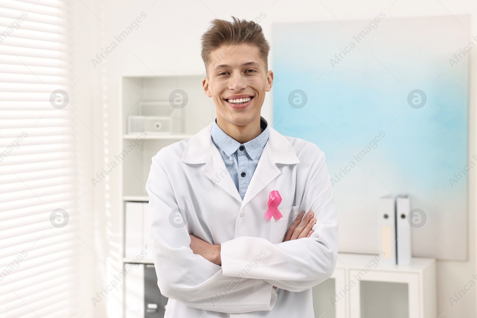 Photo of Mammologist with pink ribbon in hospital. Breast cancer awareness