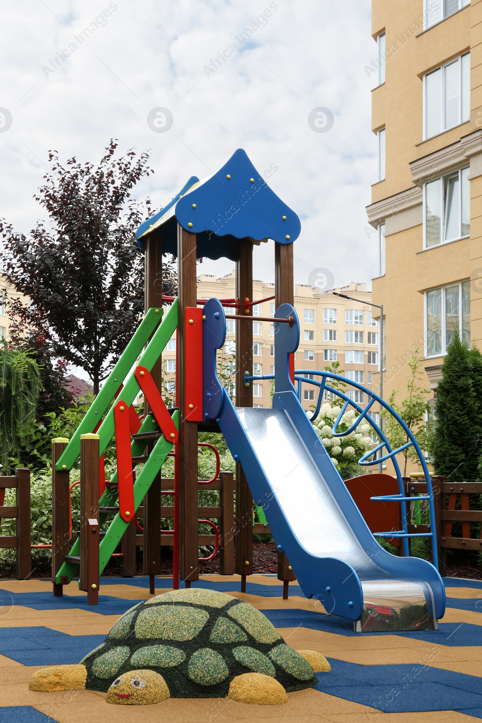 Photo of Empty outdoor children's playground with slide in residential area