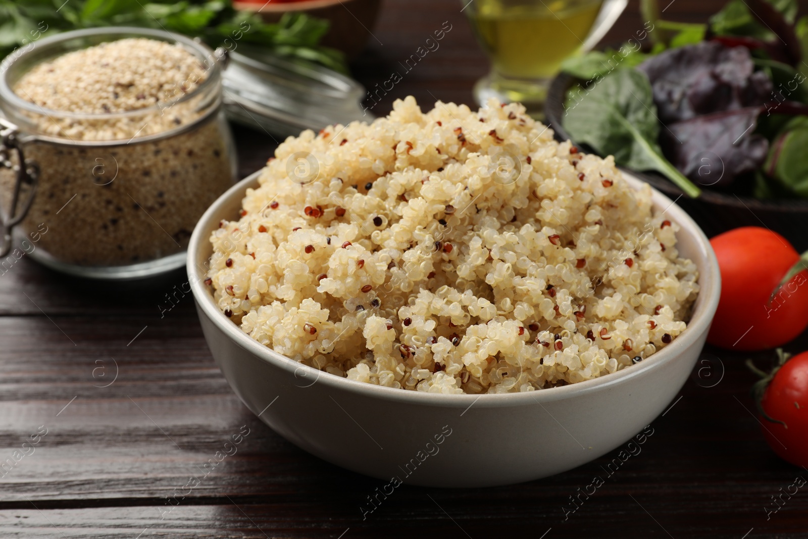 Photo of Tasty quinoa porridge in bowl on wooden table, closeup