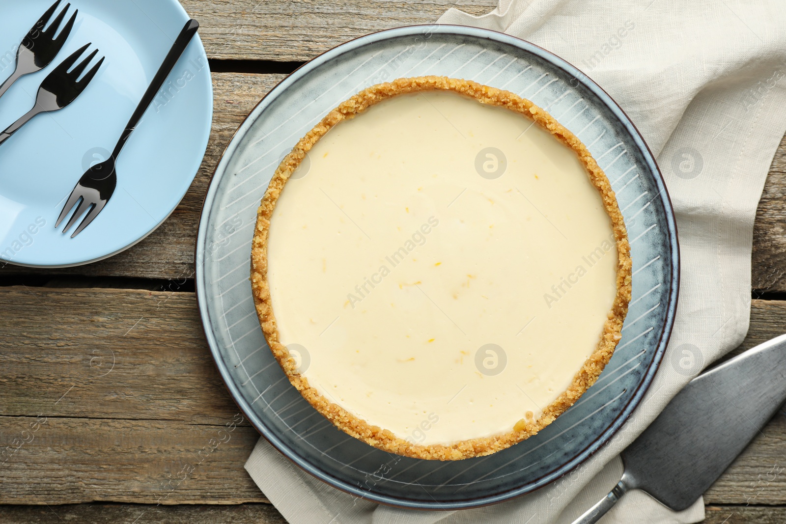 Photo of Tasty vegan tofu cheesecake served on wooden table, flat lay