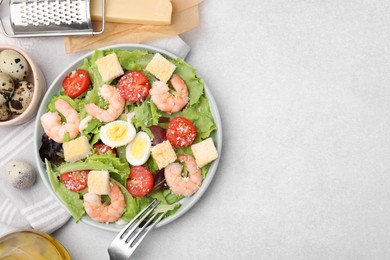 Photo of Delicious Caesar salad with shrimps and fork served on light table, flat lay. Space for text