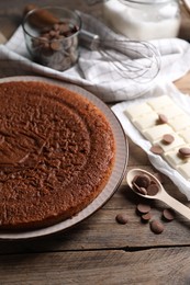 Delicious homemade sponge cake and different kinds of chocolate on wooden table