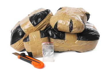 Photo of Packages with narcotics and stationery knife isolated on white