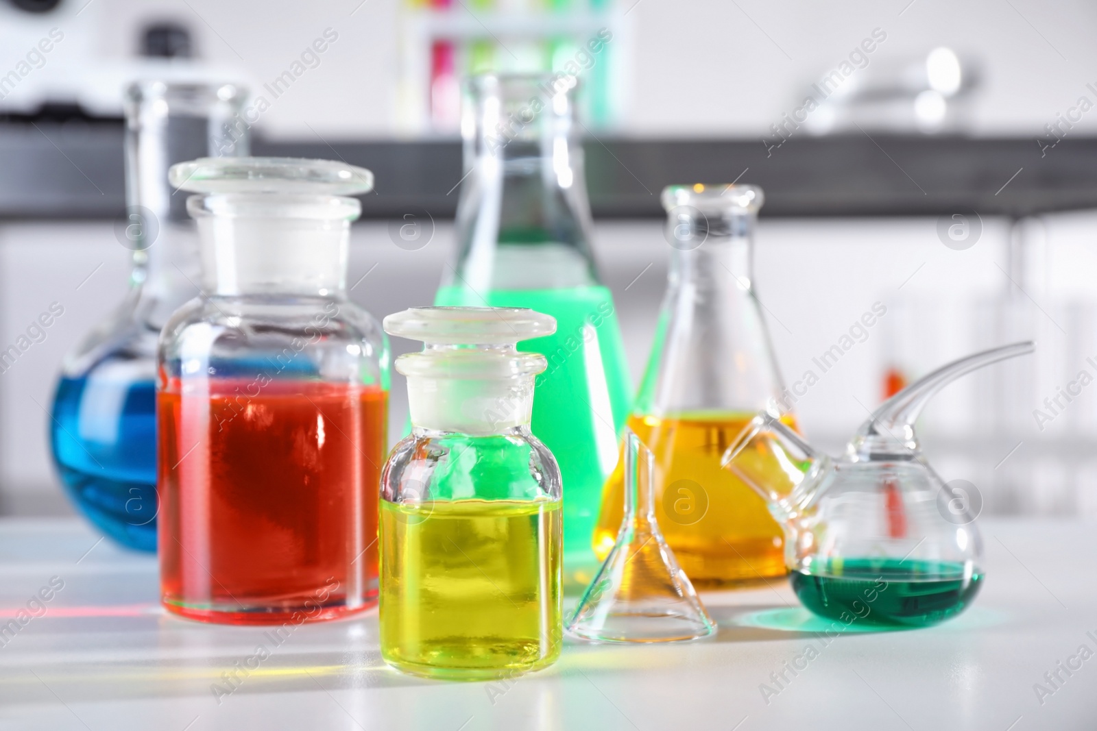 Photo of Different glassware with samples on table in chemistry laboratory