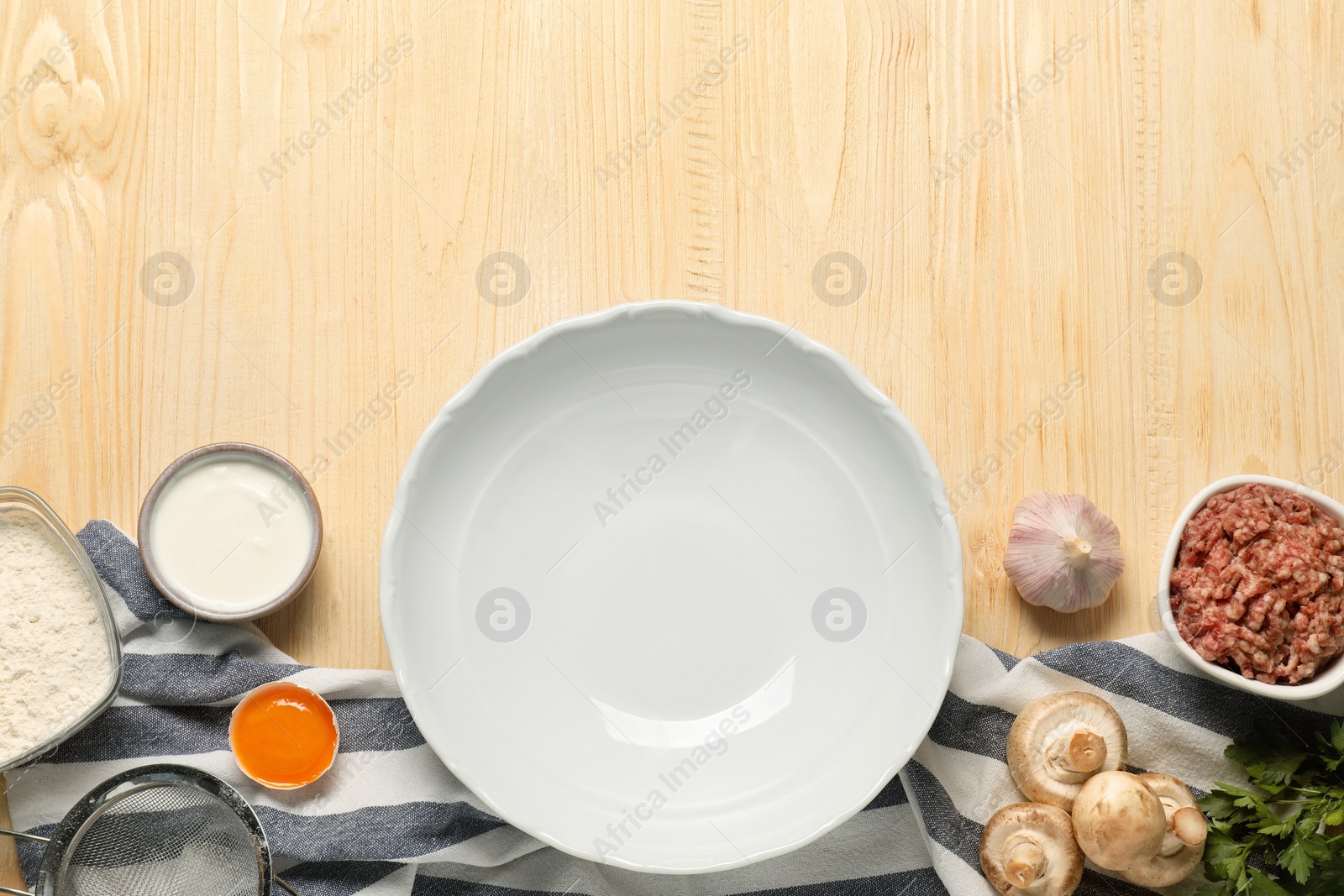 Photo of Bowl and different products on wooden table, flat lay. Space for text