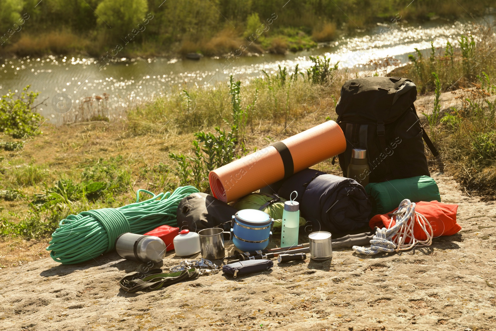 Photo of Backpack with hiking equipment on rock near river