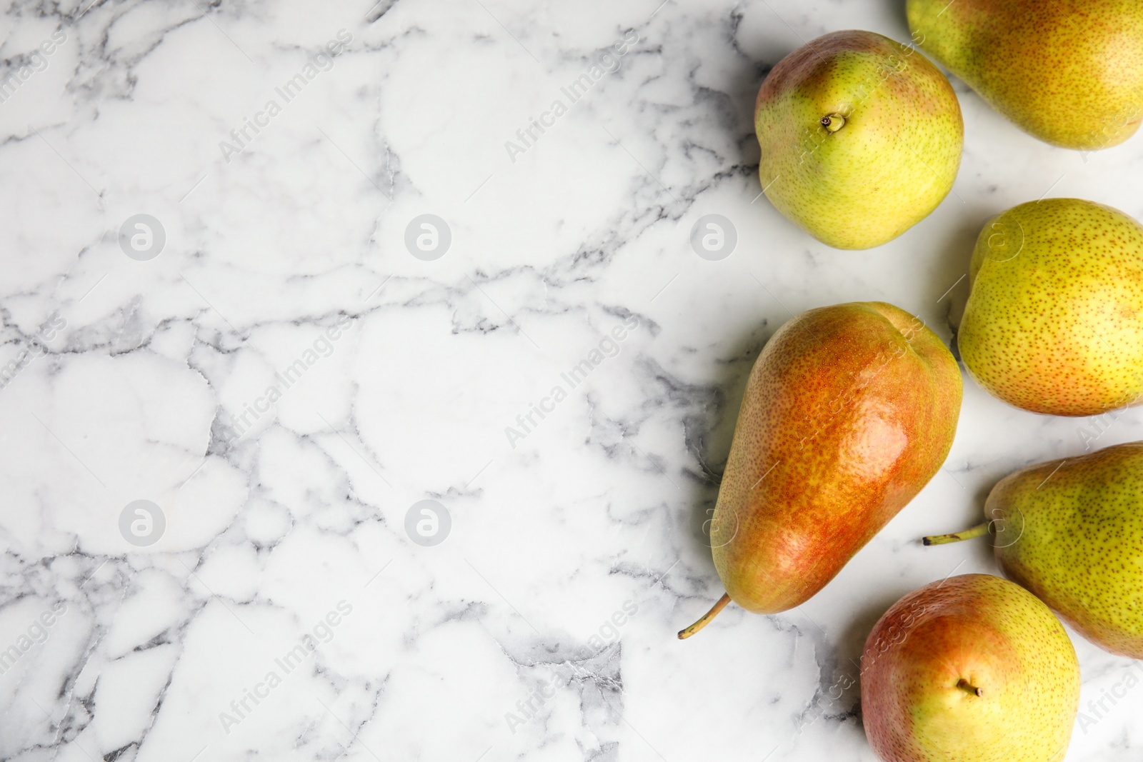 Photo of Ripe juicy pears on marble table, flat lay. Space for text