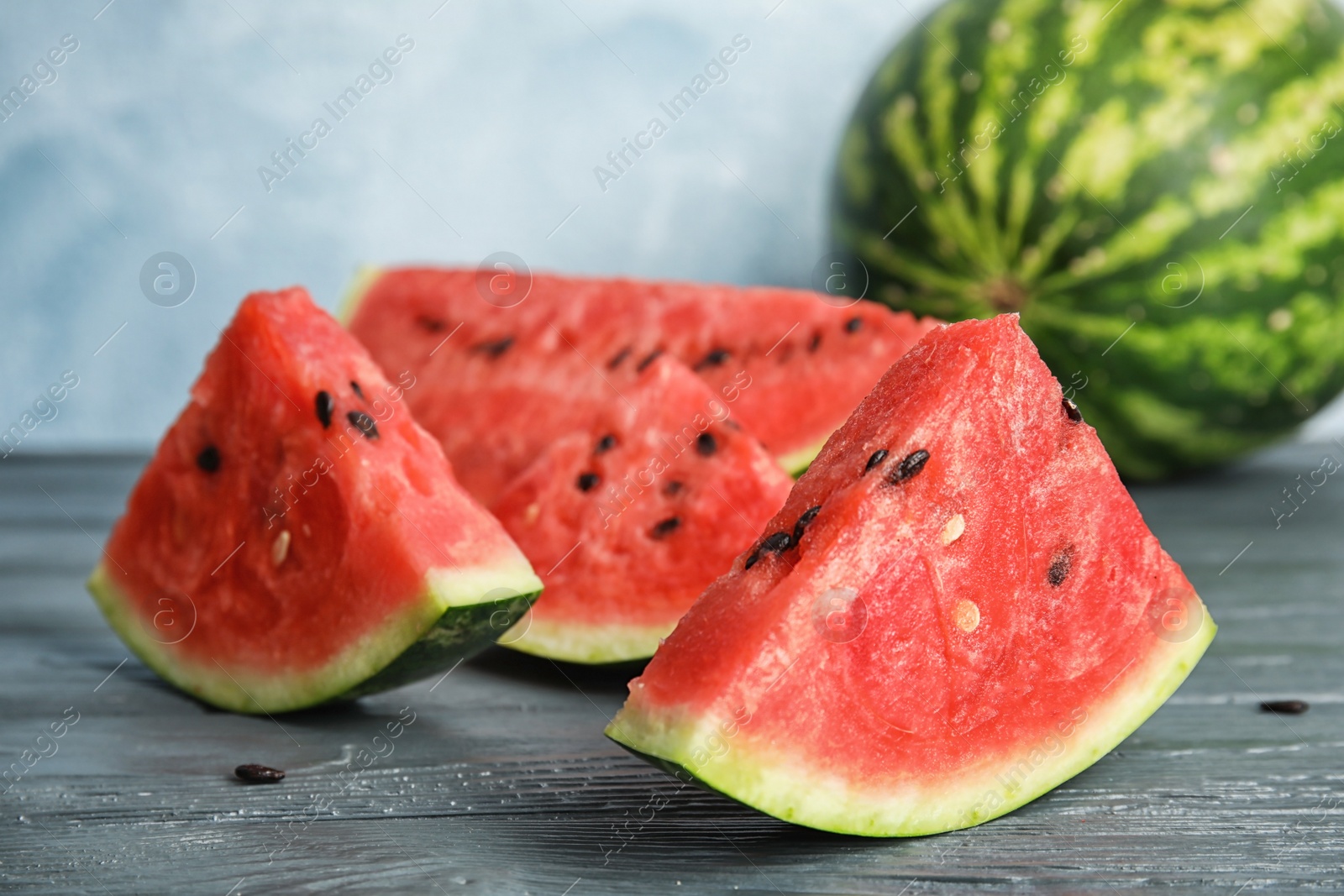 Photo of Fresh juicy watermelon with seeds on wooden table