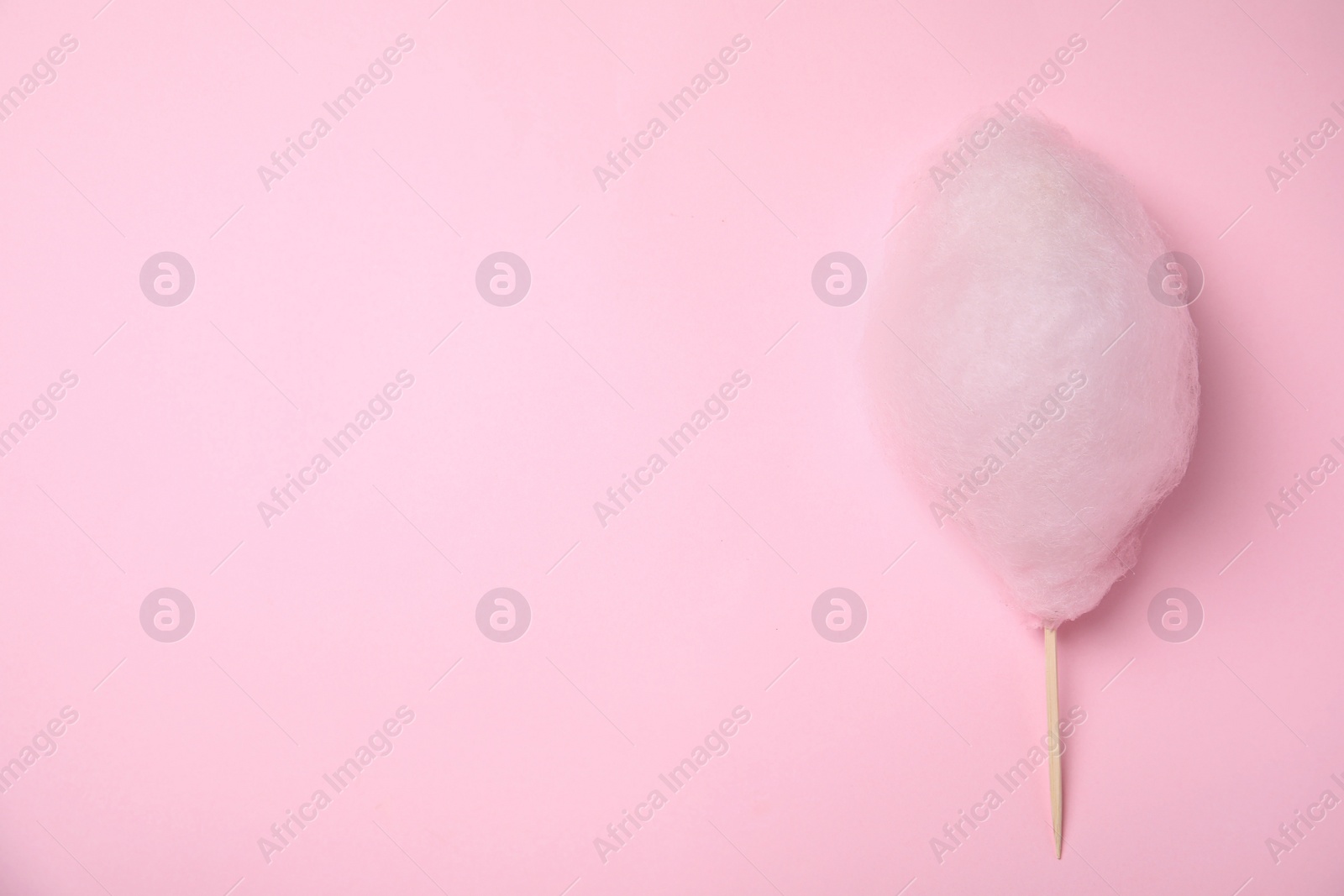 Photo of Sweet cotton candy on pink background, top view. Space for text