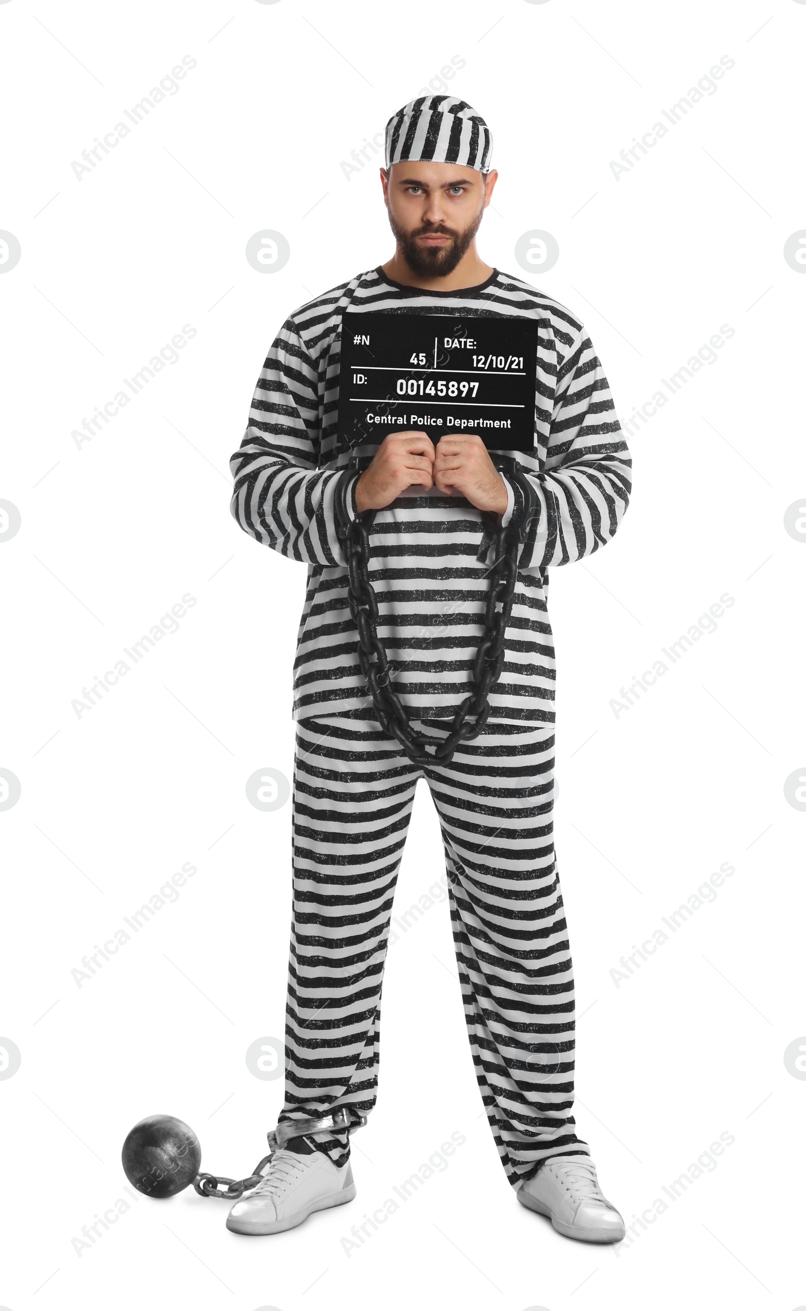 Photo of Prisoner with chained hands and metal ball holding mugshot letter board on white background