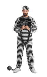 Photo of Prisoner with chained hands and metal ball holding mugshot letter board on white background