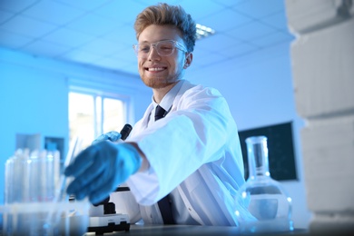 Photo of Male scientist working at table in chemistry laboratory