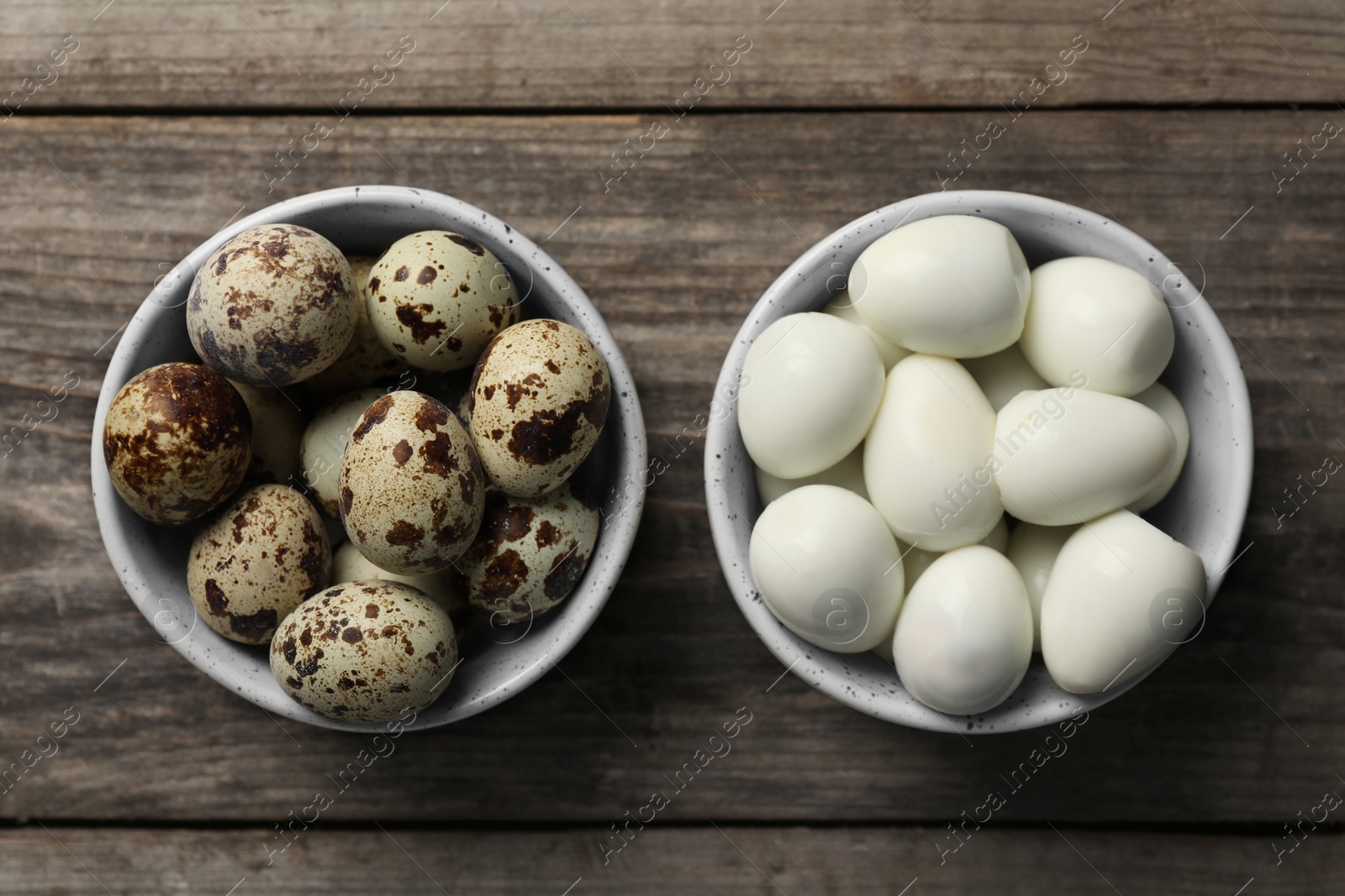 Photo of Unpeeled and peeled boiled quail eggs in bowls on wooden table, flat lay
