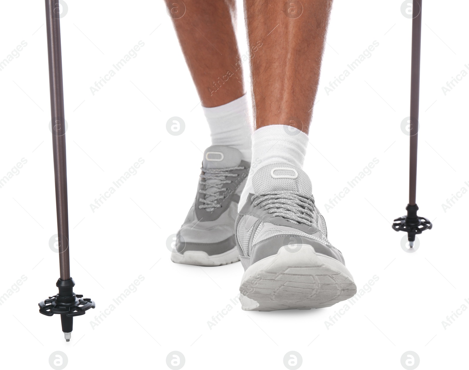 Photo of Man wearing stylish shoes with trekking poles on white background, closeup