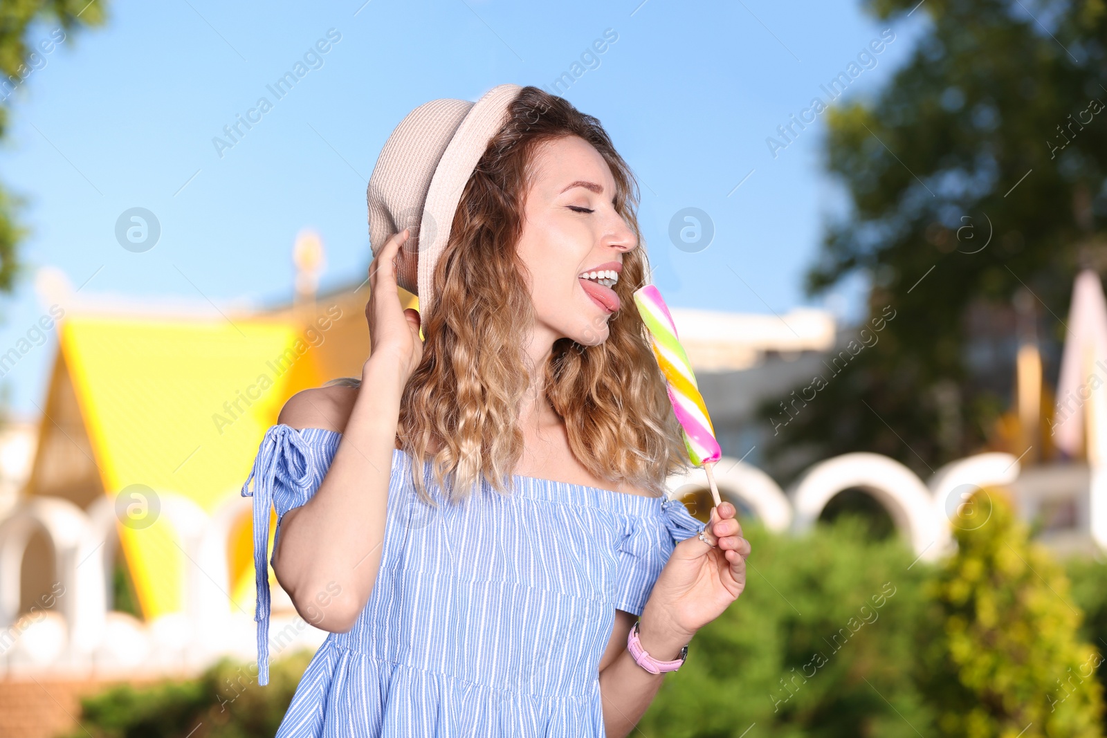 Photo of Happy young woman with delicious ice cream outdoors