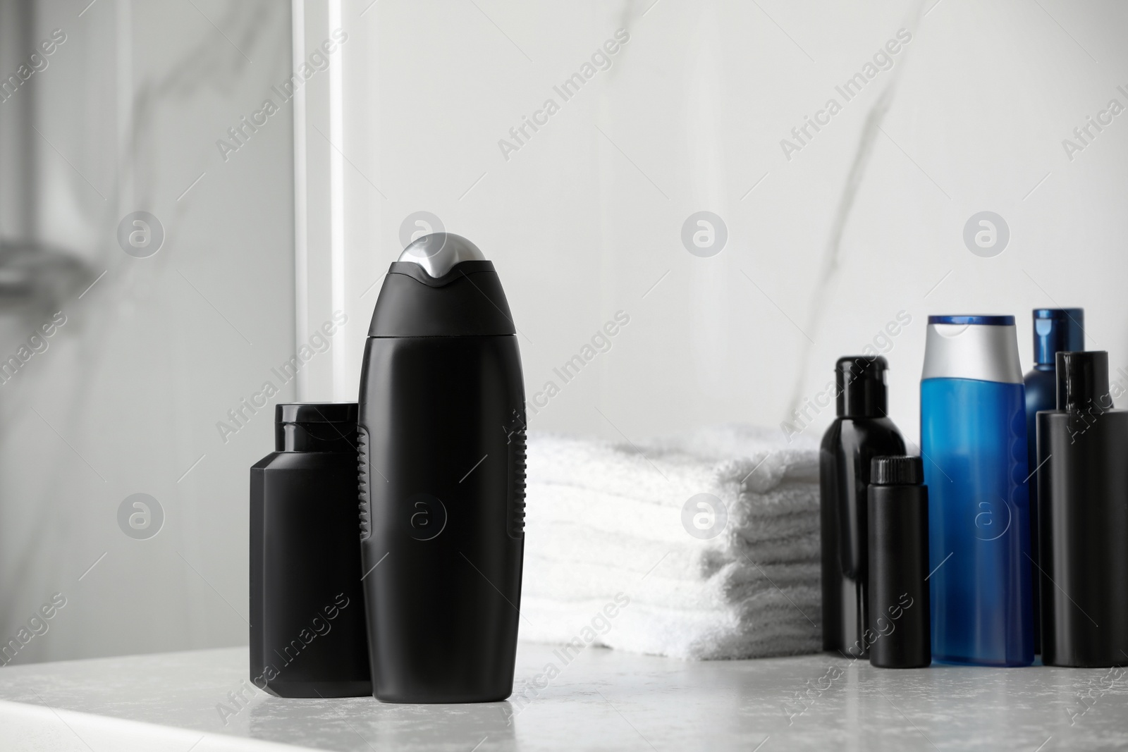 Photo of Shampoo, conditioner, other toiletries and towels on bathroom counter