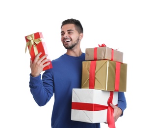 Happy young man holding Christmas gifts on white background