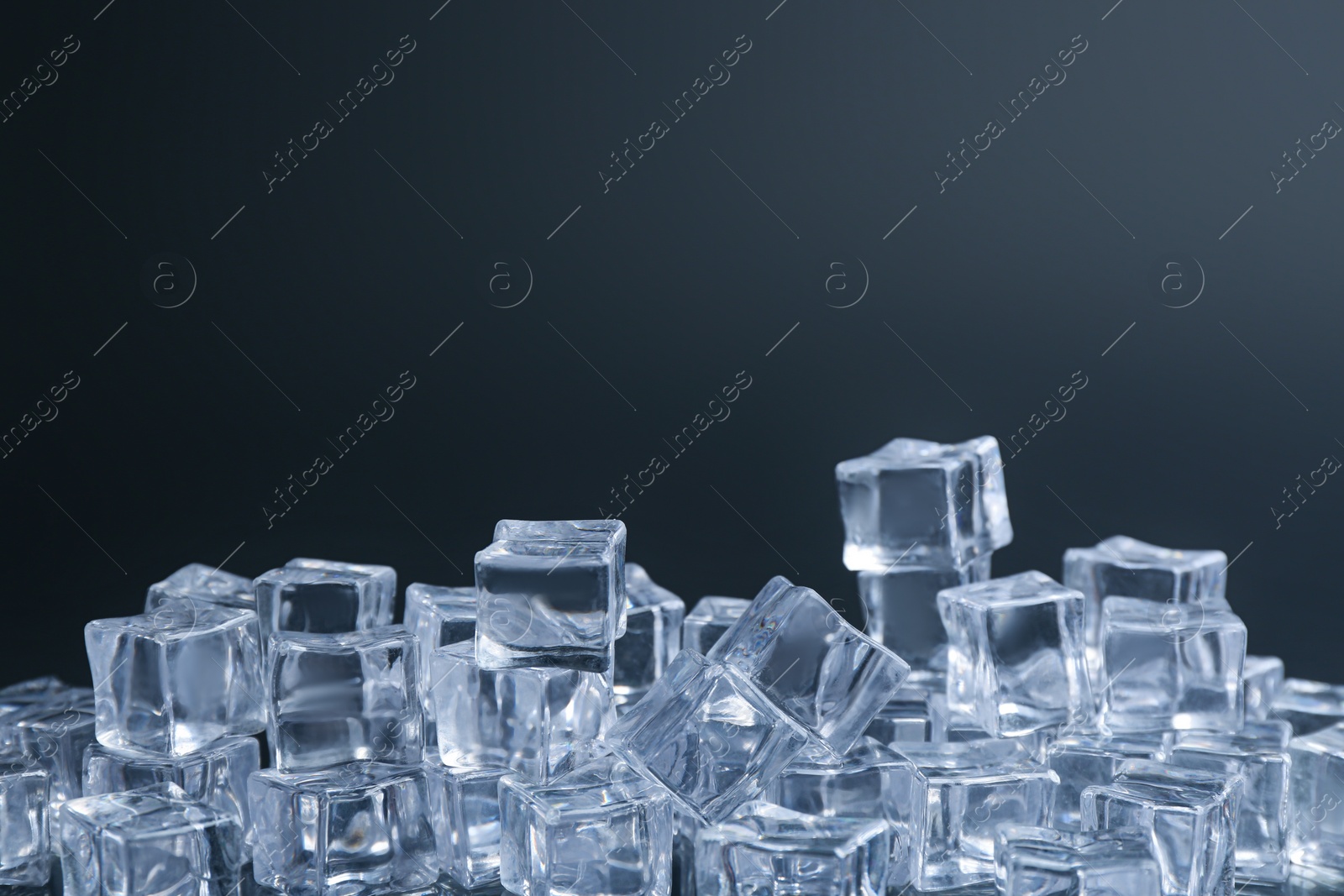 Photo of Crystal clear ice cubes on black background. Space for text