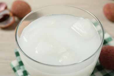 Photo of Glass with fresh lychee juice on table, closeup