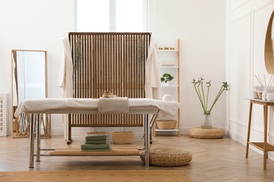 Stylish room interior with massage table in spa salon