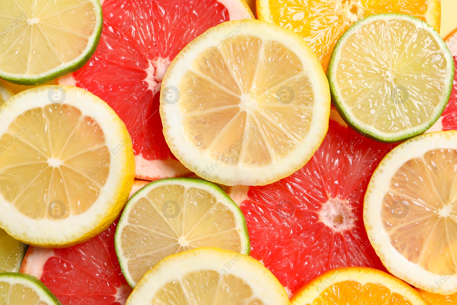 Photo of Different sliced citrus fruits as background, top view