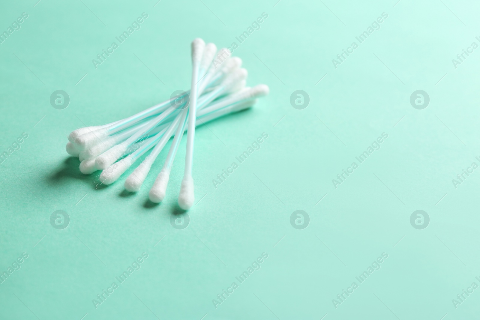 Photo of Cotton swabs on color background. Space for text