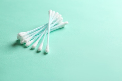 Photo of Cotton swabs on color background. Space for text