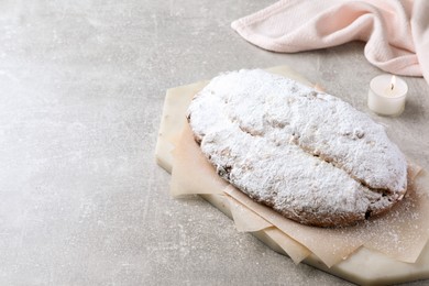 Photo of Delicious Stollen sprinkled with powdered sugar on light table. Space for text